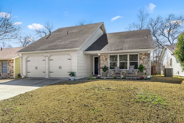 view of front of home with central AC unit, an attached garage, stone siding, concrete driveway, and a front lawn