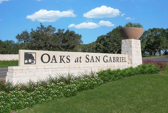 community sign featuring a lawn