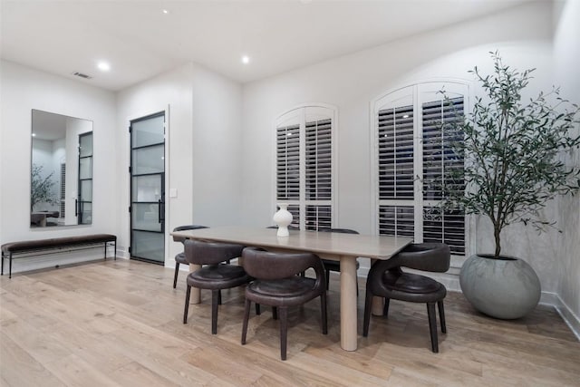 dining room featuring baseboards, light wood-type flooring, visible vents, and recessed lighting