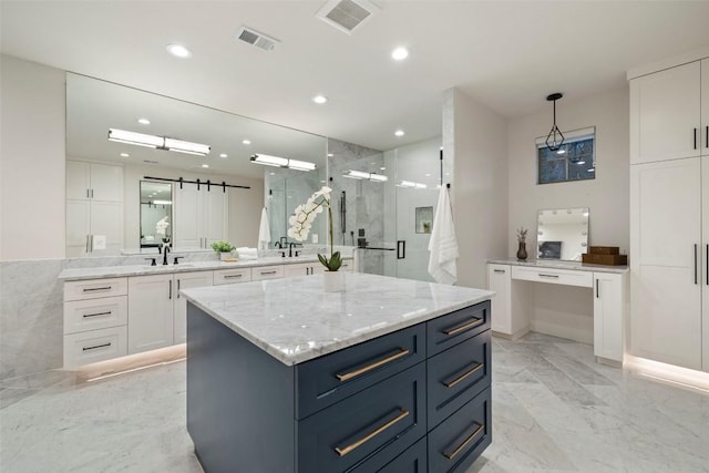 kitchen with white cabinetry, visible vents, and a barn door