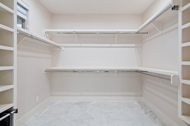 walk in closet with marble finish floor