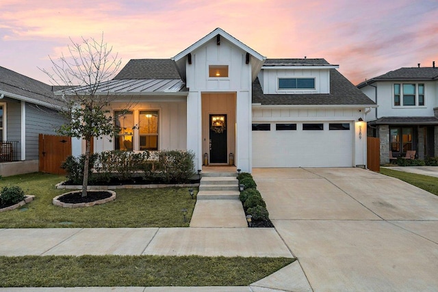 modern farmhouse style home featuring concrete driveway, board and batten siding, a standing seam roof, fence, and a garage