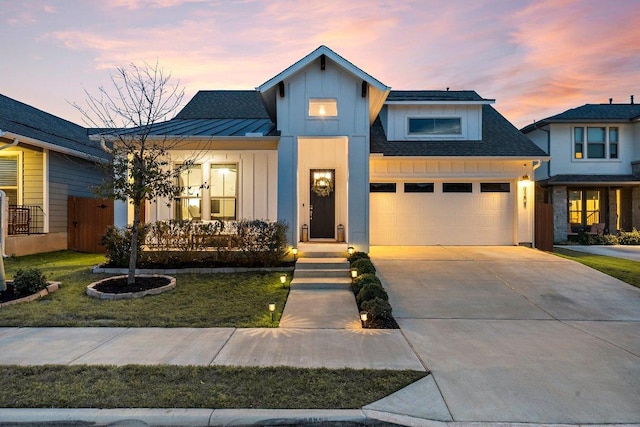 modern inspired farmhouse with covered porch, an attached garage, board and batten siding, a standing seam roof, and metal roof