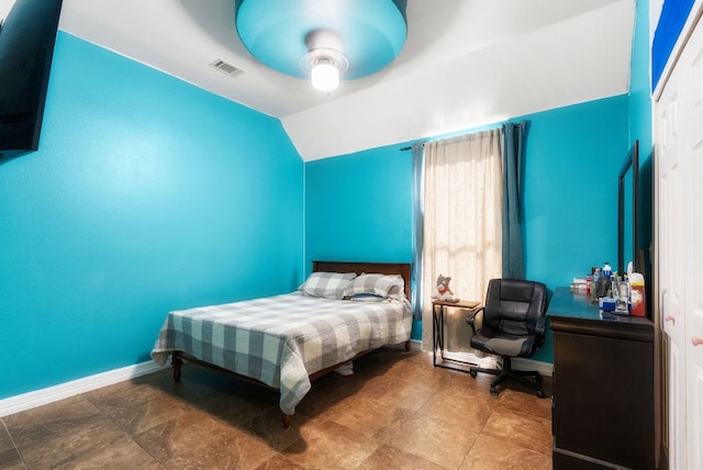 bedroom with a ceiling fan, lofted ceiling, visible vents, and baseboards