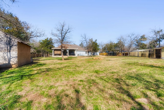 view of yard featuring an outdoor structure and fence