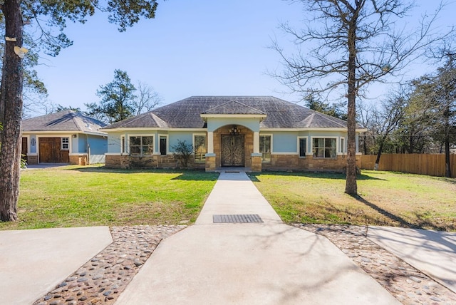 view of front of house featuring a front yard, fence, and stucco siding