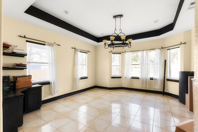 unfurnished dining area with light tile patterned floors, a notable chandelier, visible vents, baseboards, and a tray ceiling