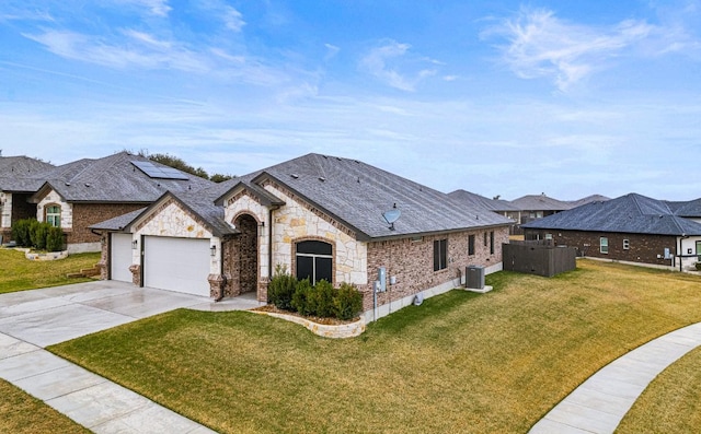 french provincial home featuring a garage, driveway, stone siding, central AC, and a front yard