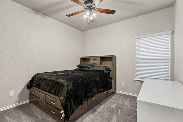 carpeted bedroom with ceiling fan, a textured wall, and baseboards