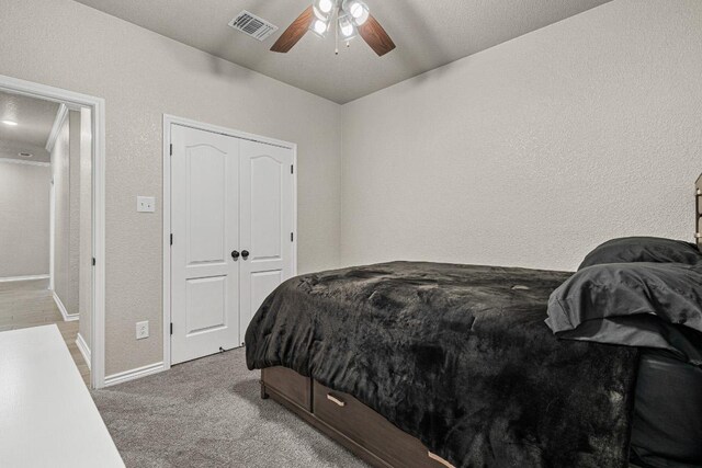 bedroom with carpet floors, a closet, visible vents, ceiling fan, and baseboards