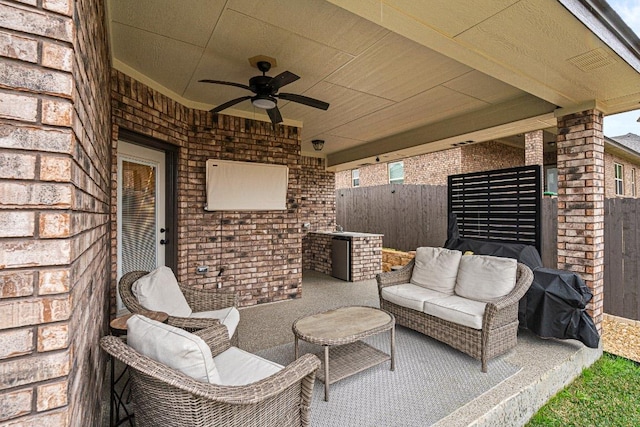 view of patio featuring a ceiling fan, fence, area for grilling, and an outdoor hangout area