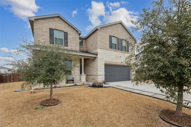 traditional home with brick siding, fence, a garage, stone siding, and driveway