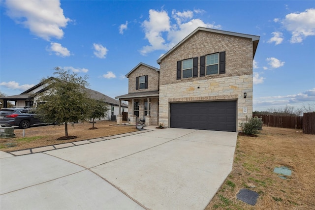 traditional home featuring an attached garage, fence, driveway, stone siding, and a front yard