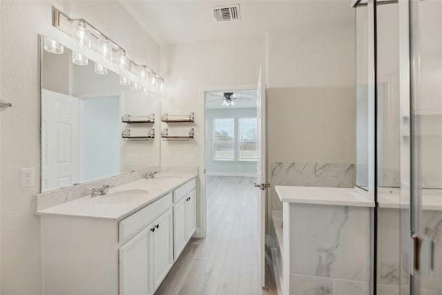 full bath featuring double vanity, visible vents, a sink, and wood finished floors