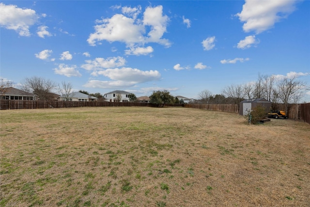 view of yard with a fenced backyard, a shed, and an outdoor structure