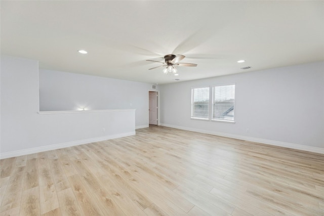 spare room featuring baseboards, a ceiling fan, and light wood-style floors