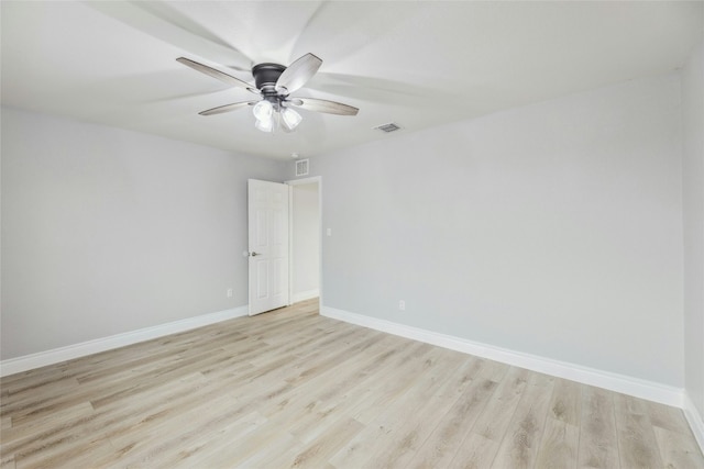 empty room featuring light wood-style floors, visible vents, ceiling fan, and baseboards