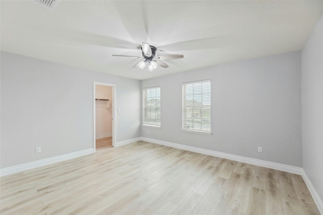 spare room featuring visible vents, ceiling fan, light wood-style flooring, and baseboards