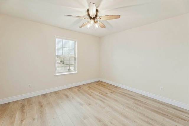 spare room featuring ceiling fan, light wood-type flooring, and baseboards