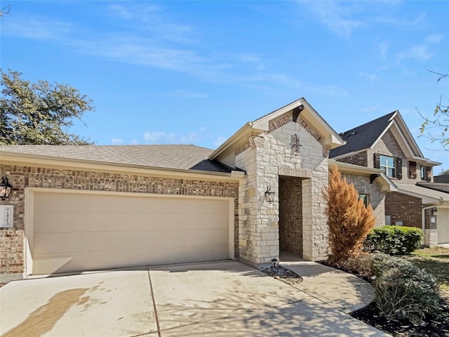 view of front of property featuring a garage, a shingled roof, brick siding, driveway, and stone siding