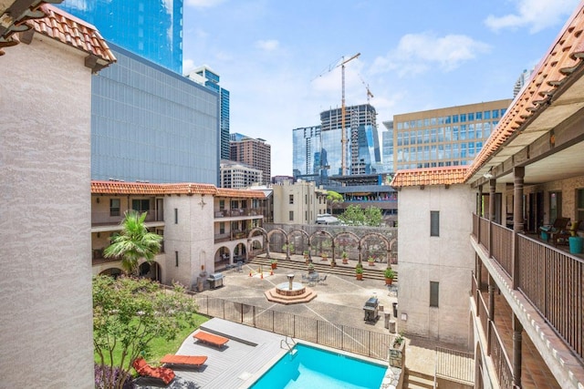 exterior space with a fenced in pool, a patio area, and a city view