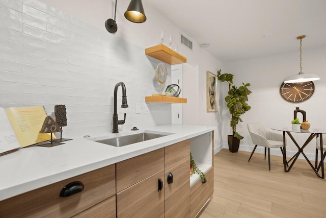 kitchen with light countertops, visible vents, a sink, and open shelves