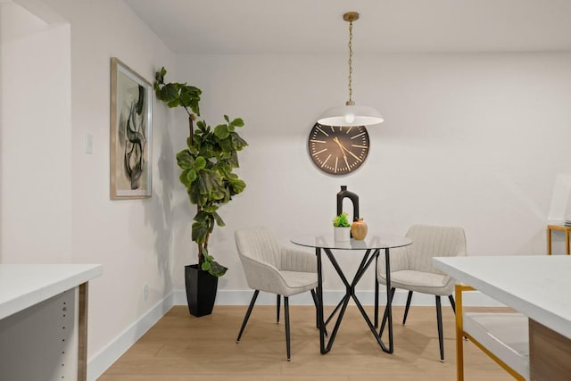 dining area featuring baseboards and light wood finished floors