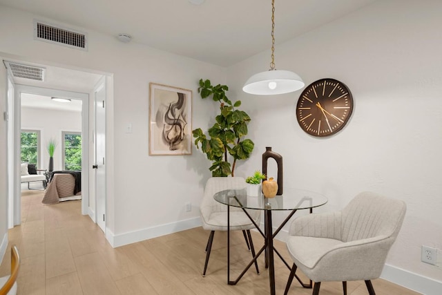 dining space featuring baseboards, visible vents, and light wood-style floors