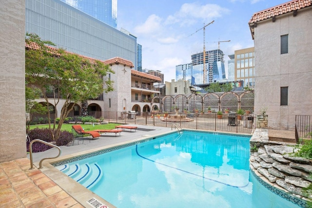 community pool featuring a patio area and fence