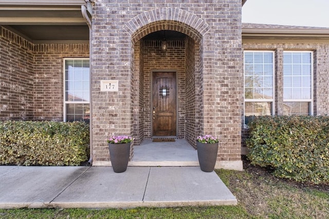 view of exterior entry with brick siding