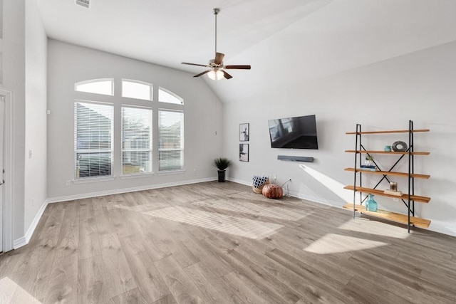 unfurnished living room with baseboards, a ceiling fan, vaulted ceiling, and wood finished floors