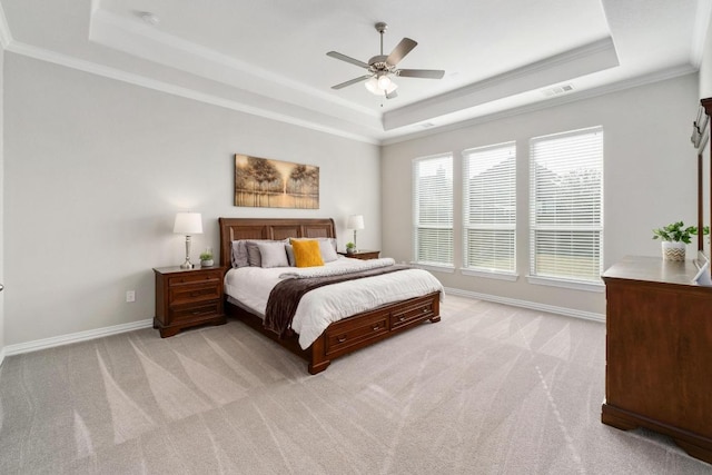 bedroom with a tray ceiling, light carpet, visible vents, and baseboards