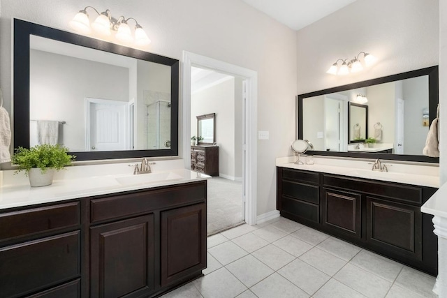 full bath featuring a shower stall, vanity, baseboards, and tile patterned floors