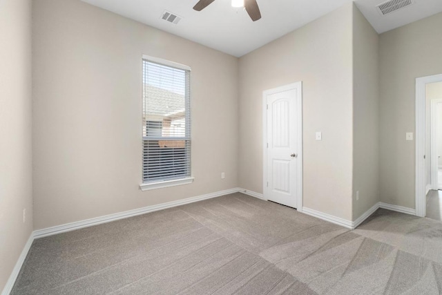 spare room featuring carpet floors, visible vents, baseboards, and a ceiling fan