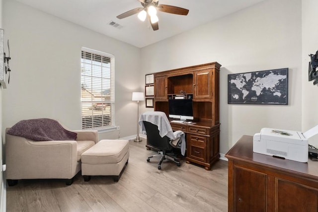 office space featuring a ceiling fan, baseboards, visible vents, and light wood finished floors