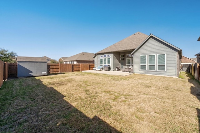 rear view of house with a lawn, a patio, a fenced backyard, an outbuilding, and a shed