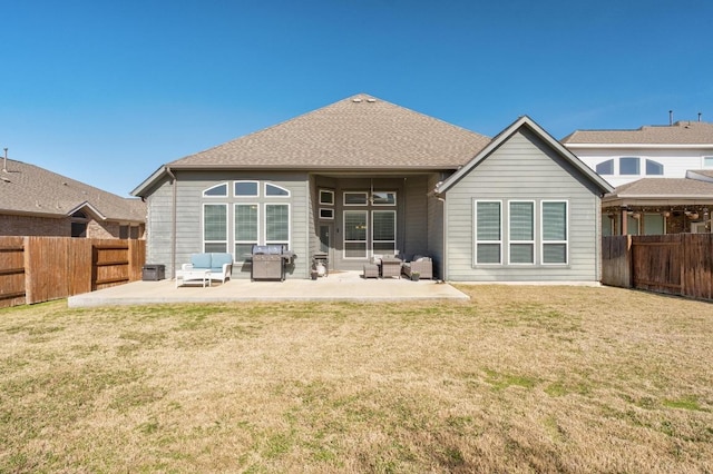 rear view of house featuring a patio area, a fenced backyard, roof with shingles, and a yard