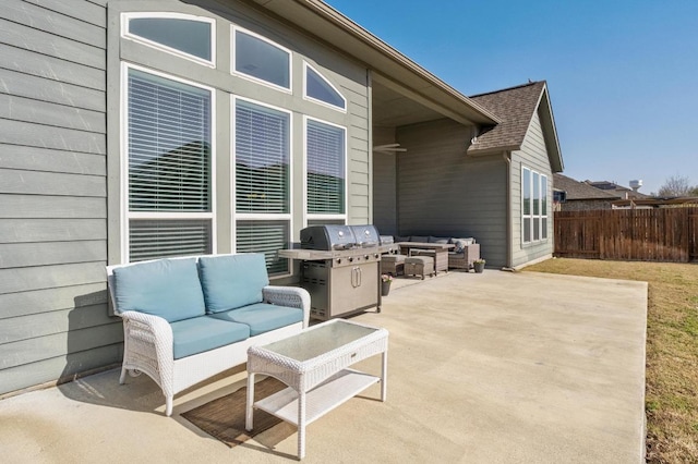 view of patio featuring a grill, fence, and an outdoor living space