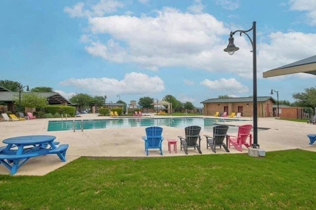 community pool featuring fence, a lawn, and a patio