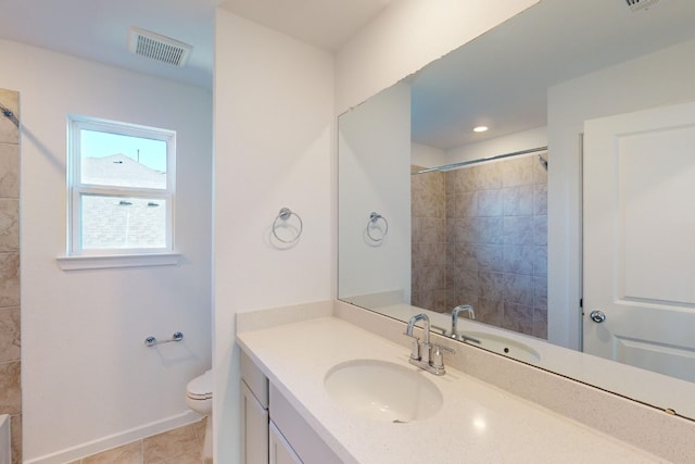 bathroom with toilet, vanity, visible vents, baseboards, and tile patterned floors