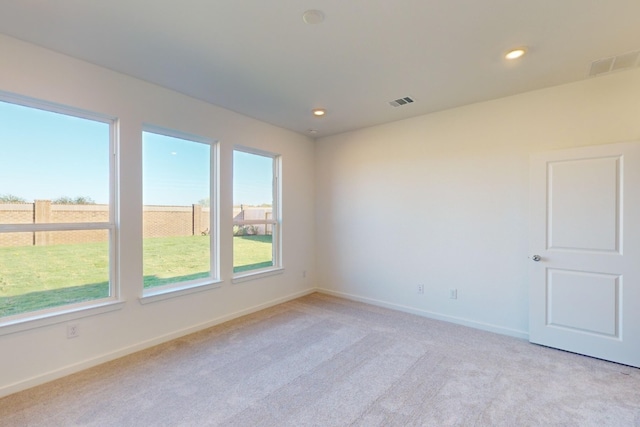 unfurnished room with recessed lighting, visible vents, light carpet, and baseboards