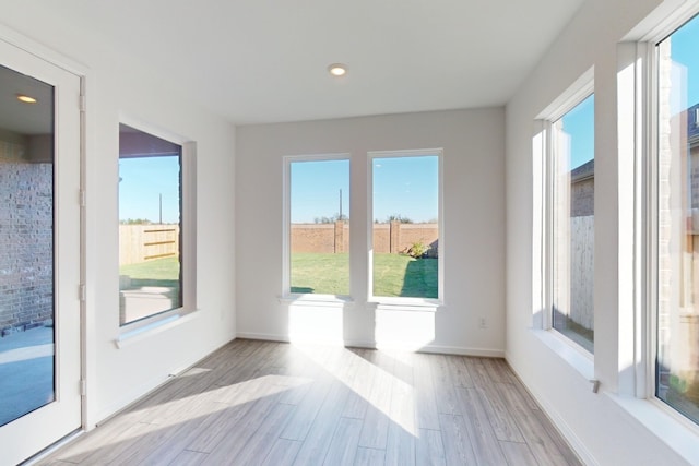 doorway to outside featuring light wood-type flooring, baseboards, and recessed lighting