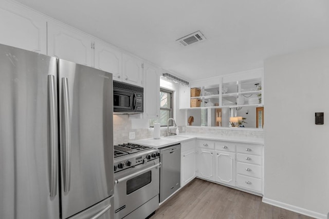 kitchen with a sink, visible vents, white cabinetry, appliances with stainless steel finishes, and light wood-type flooring