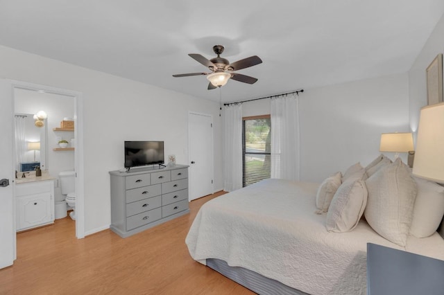 bedroom with light wood-style floors, baseboards, a ceiling fan, and ensuite bathroom