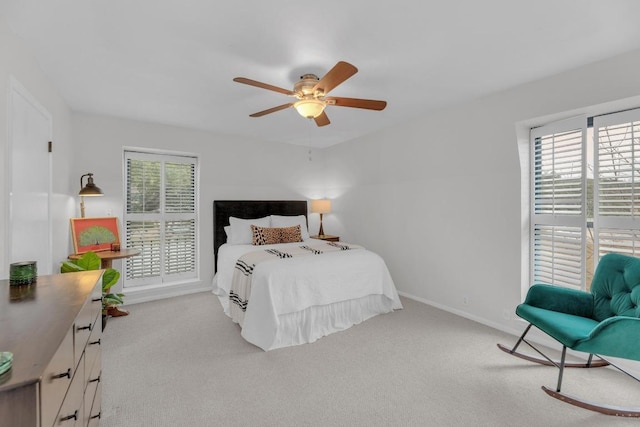 carpeted bedroom with multiple windows, ceiling fan, and baseboards