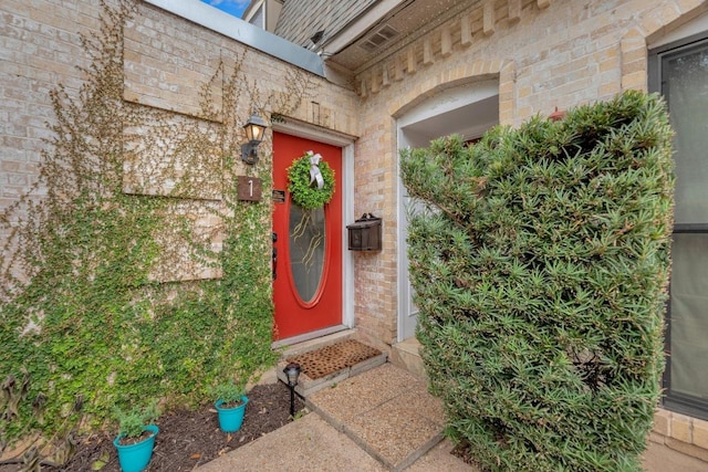 entrance to property featuring brick siding