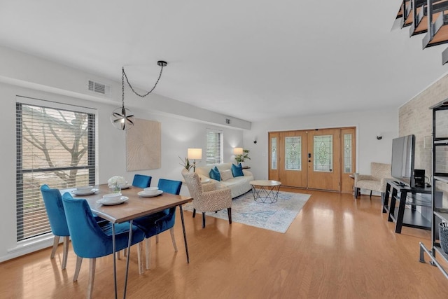 dining space featuring stairway, visible vents, and light wood-style flooring