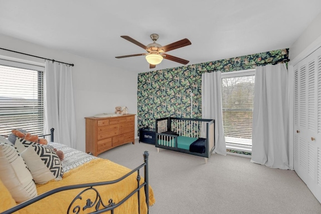 carpeted bedroom featuring ceiling fan, a closet, and wallpapered walls