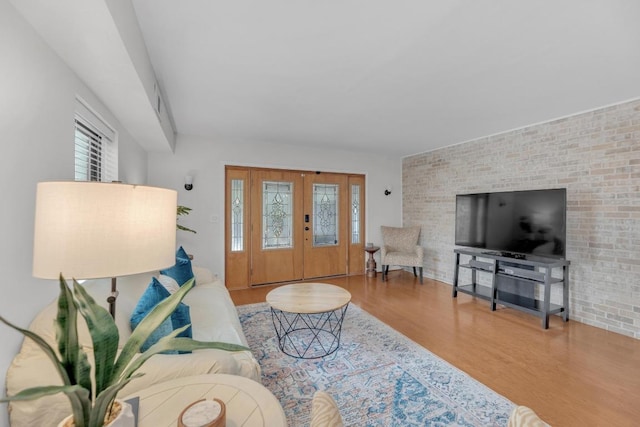 living room with brick wall and wood finished floors