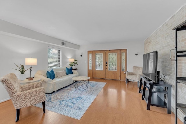 living area featuring light wood-style flooring and visible vents